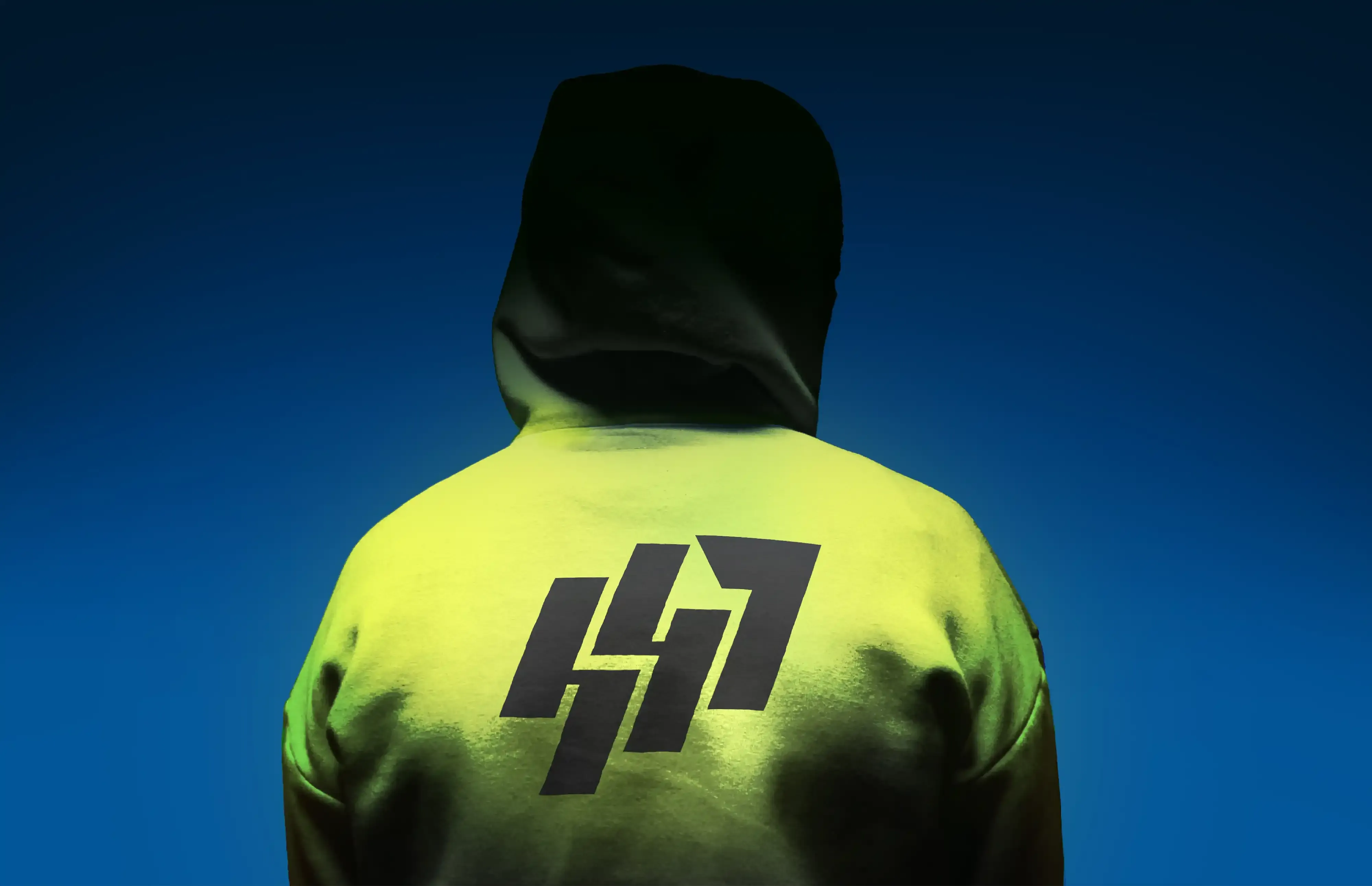 House47 streetwear model wearing a fluorescent hoodie with the interlocking badge on the back.