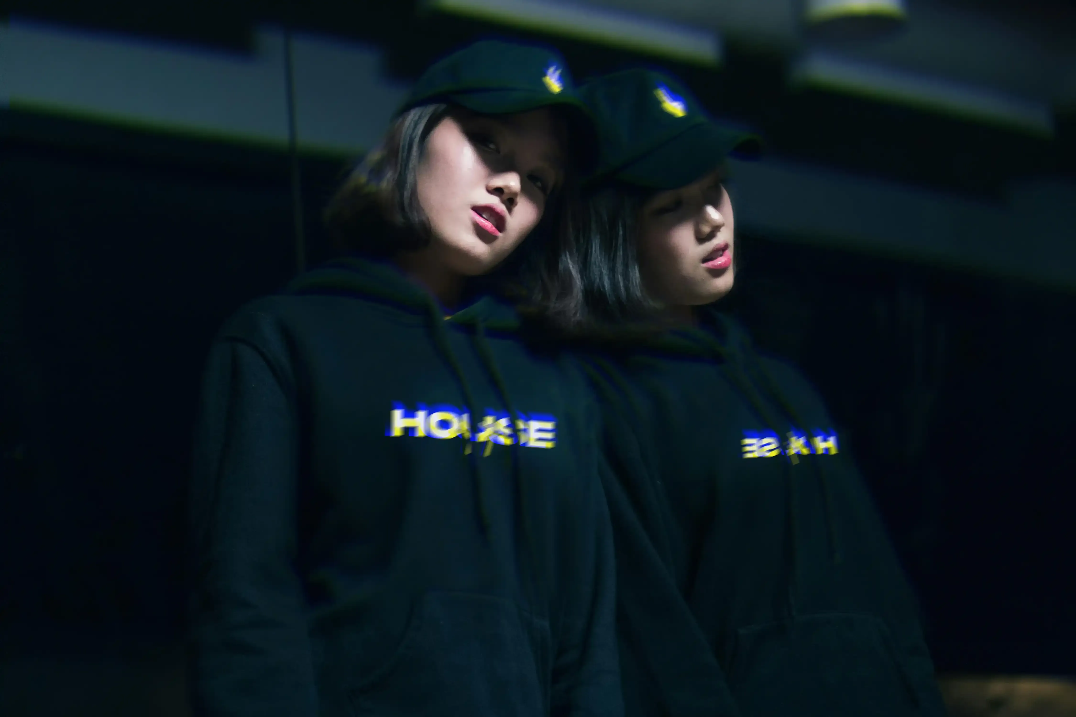 House47 fashion portrait showing the wordmark on a black hoodie and cap.